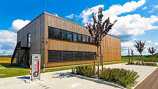 Foto, Außenansicht der mit Holz verkleideten Forschungshalle in Feuchtwangen.