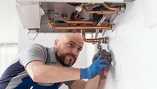 Foto, eine Heizungsinstallateur arbeitet an einer Heiztherme